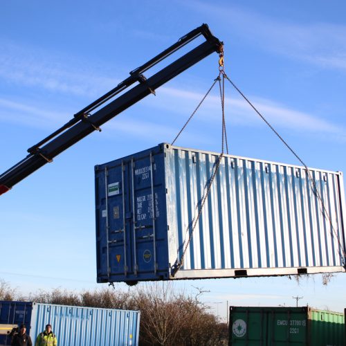 Container loading - 20ft new ‘one trip’ container being lifted from the bottom with a HIAB assisted vehicle.