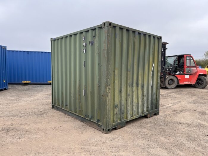 Rear-right angle of 8ft used green storage container in open yard