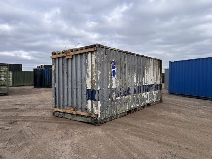 Back corner of a battered 20ft container with peeling grey and blue paint stripes