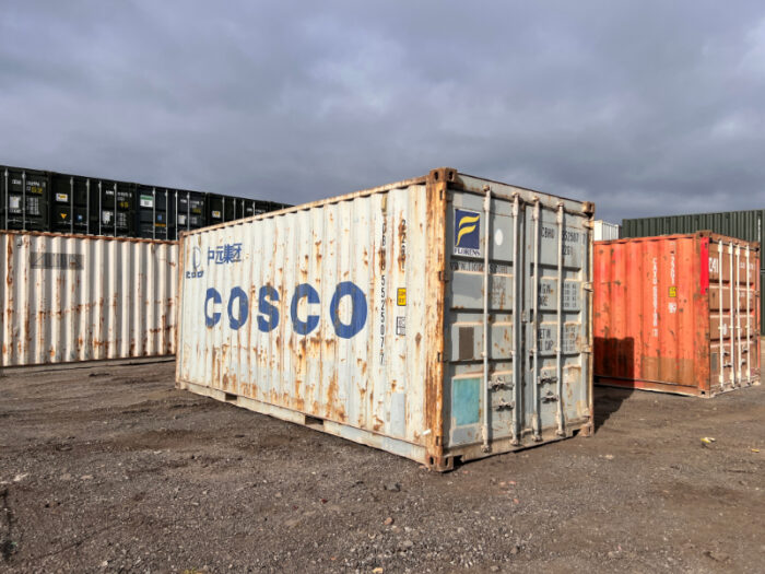 Angled view of a COSCO 20ft container with double doors and exterior rust