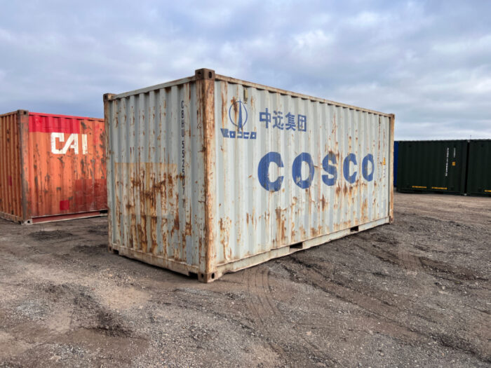 Side view of a weathered 20ft container with COSCO branding and rust
