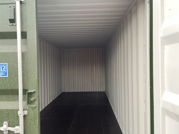 Interior view of clean 20ft storage container with white corrugated steel walls and dark floor.